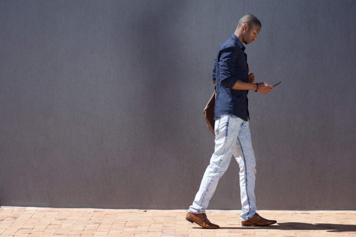 Man walking while looking at smartphone