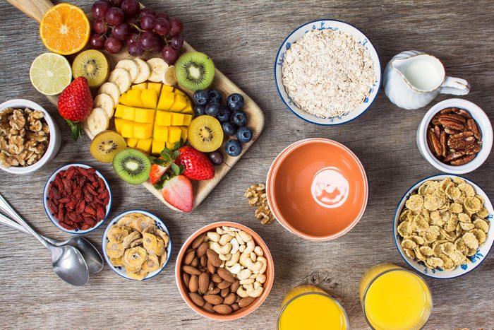 Healthy morning breakfast selection: cereals, nuts, orange juice, fruits, berries