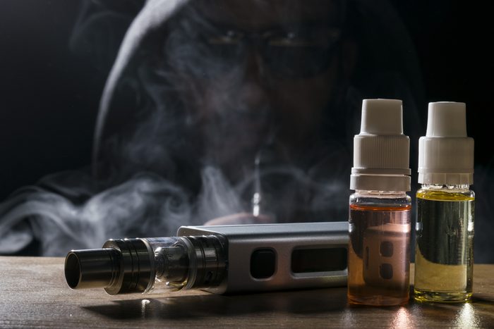 isolated vaping e liquid and vaping device for electronic cigarette on a dark background.