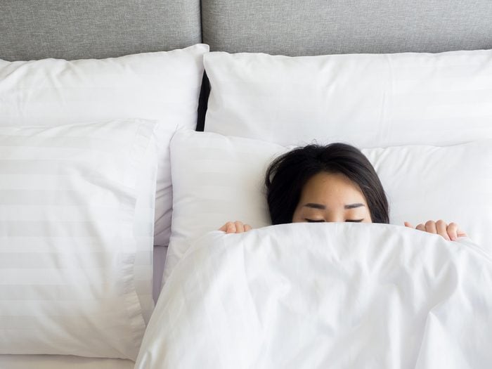 woman in bed with covers up to her nose