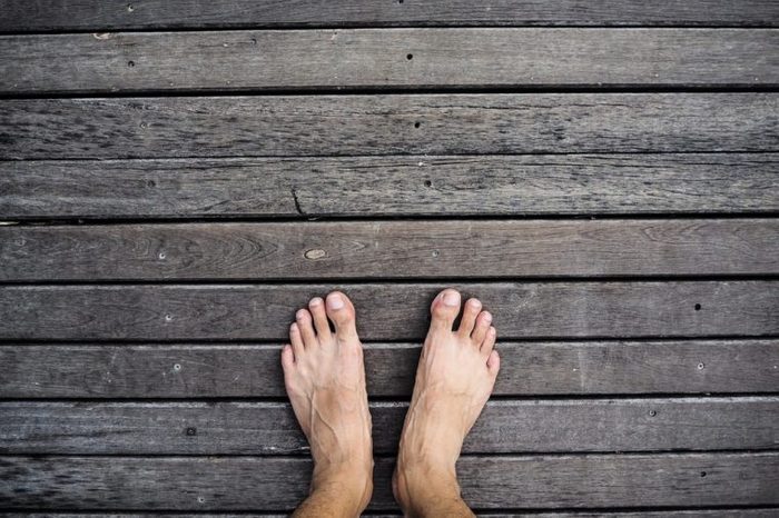 Bare feet standing on wooden floor