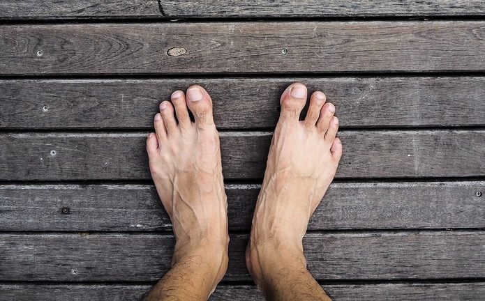 Bare feet standing on wooden floor