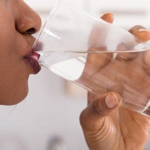 Close-up Of A Woman's Hand Drinking Glass Of Water
