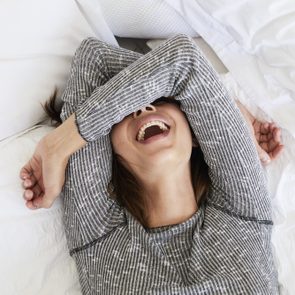 Laughing babe in bed, overhead view