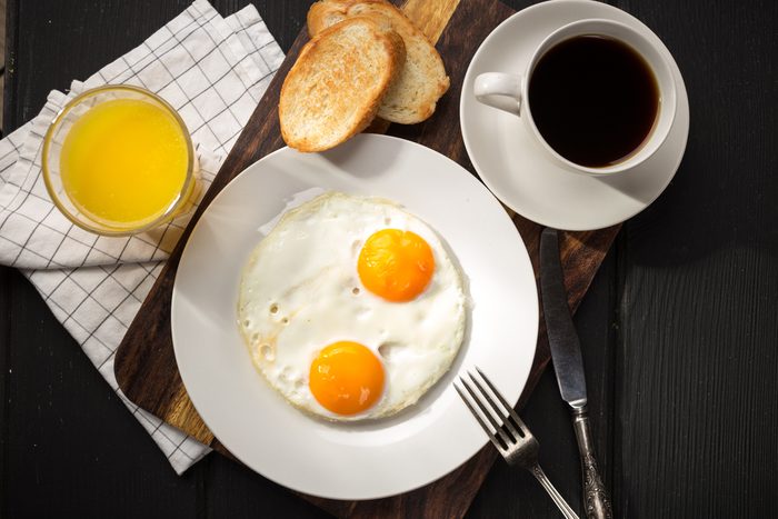Fried eggs with toasts and coffee on the table