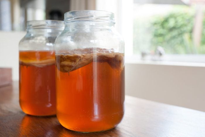 Kombucha tea in jars with the bacteria culture in place to ferment the brew.