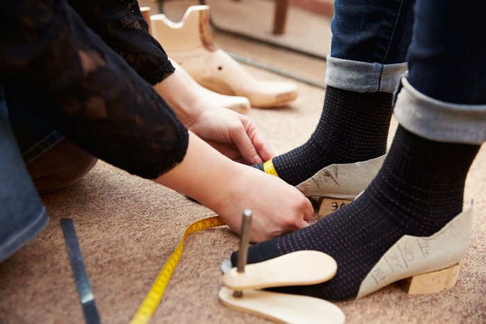 Shoemaker measuring customer's feet, close up