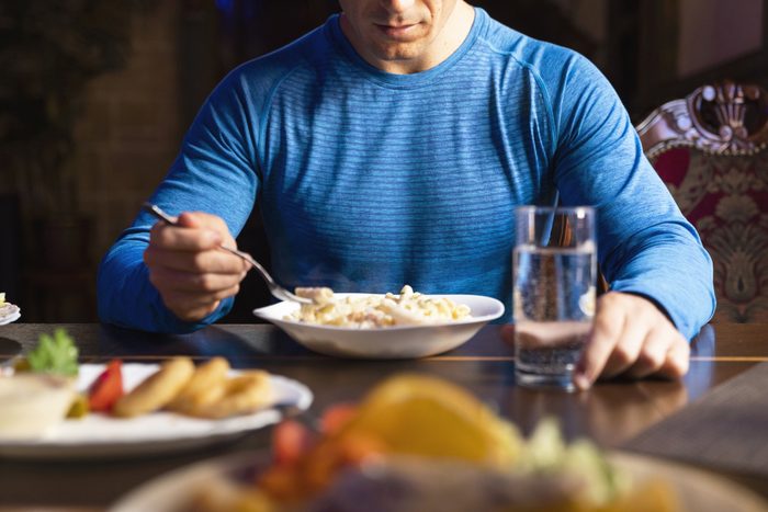 cropped shot of man eating at table