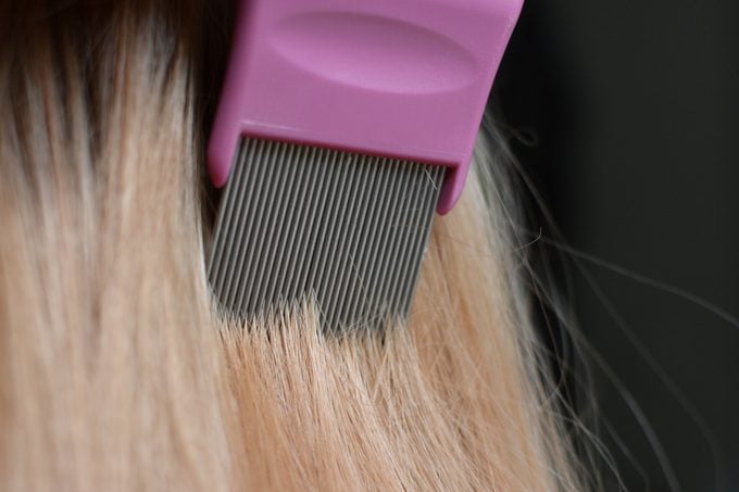 combing through hair with lice comb