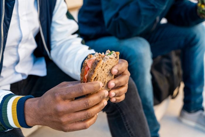 close up of man holding a sandwhich