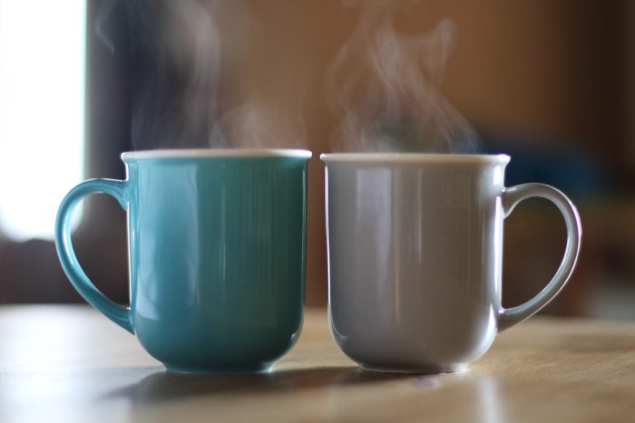 two cups of hot coffee on table