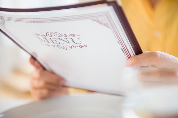 close up of person holding menu at restaurant