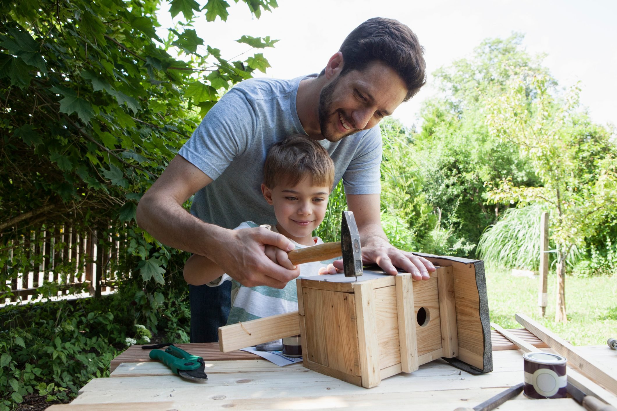 father and son building a birdhouse together