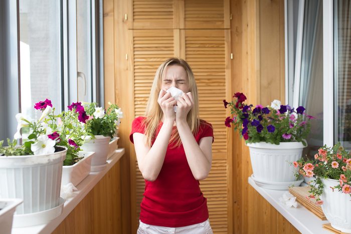 Allergy to flowering. A young girl sneezes. Irritation