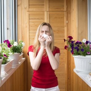 Allergy to flowering. A young girl sneezes. Irritation