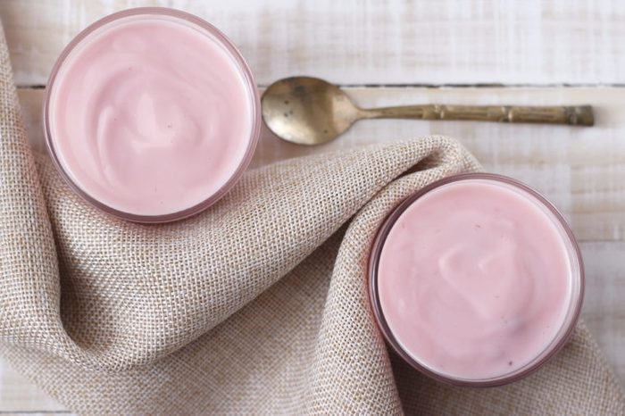 two glasses of strawberry yogurt with spoon