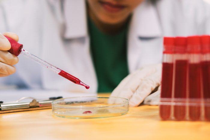 Lab technician holding a blood tube test.