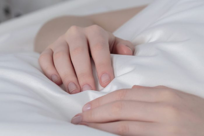 Крупный план рук больной девушки с периферической венозной линией