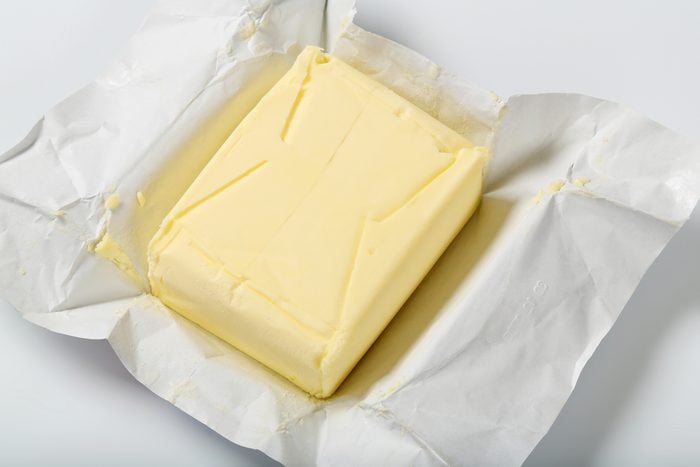 block of fresh butter on white background - close up