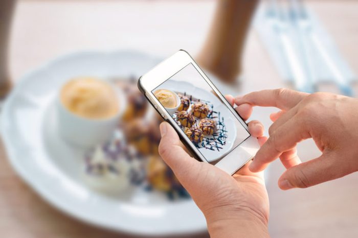 Man holding smartphone and take photo of food