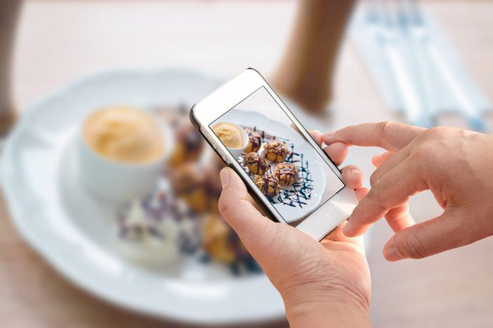 Man holding smartphone and take photo of food