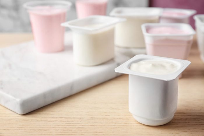 Plastic cups with tasty yogurt on table