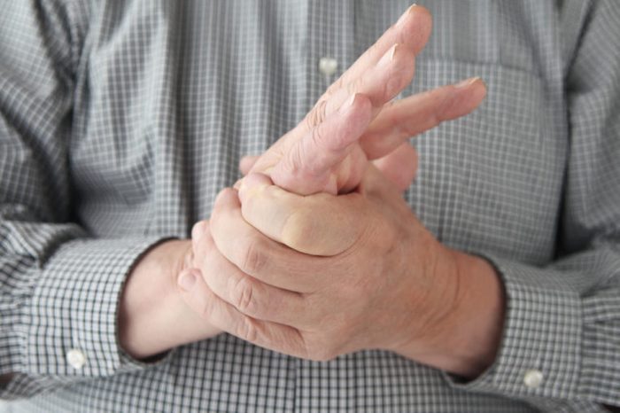a man tries to restore feeling in his hand by squeezing