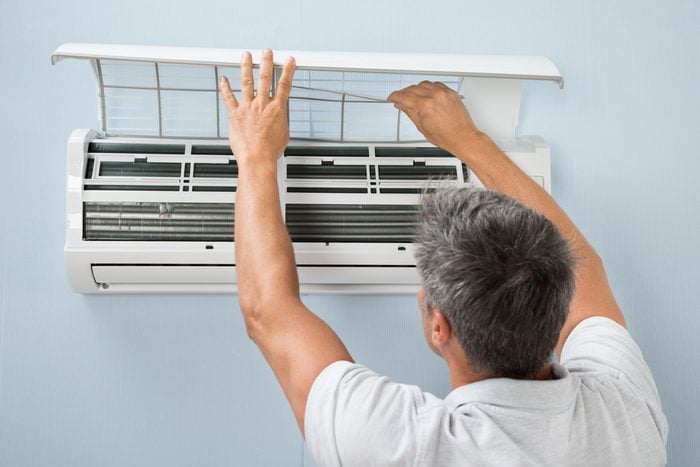 man cleaning air conditioner