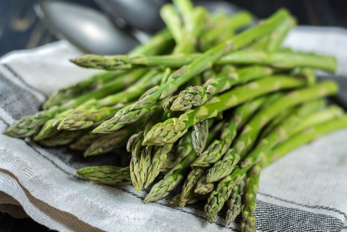 bunch of green asparagus on a dish towel