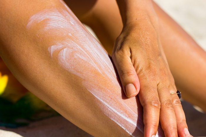 woman spreading sunscreen on leg