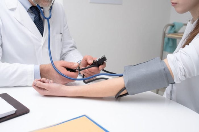 doctor checking blood pressure of a patient