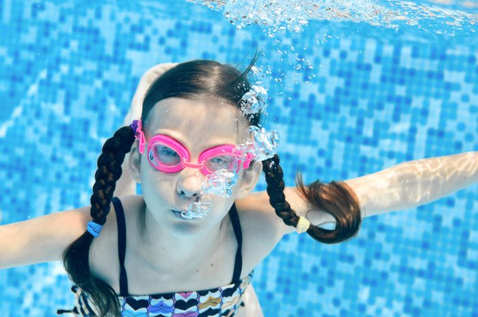 girl swimming underwater in pool