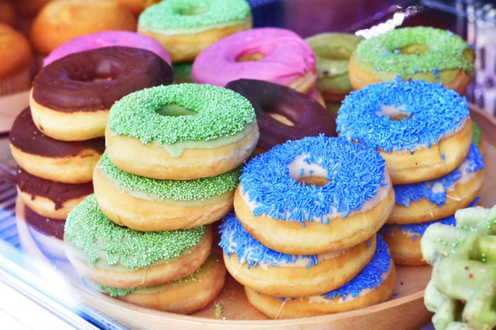 Doughnuts with sprinkles piled on a plate