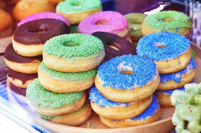 Doughnuts with sprinkles piled on a plate