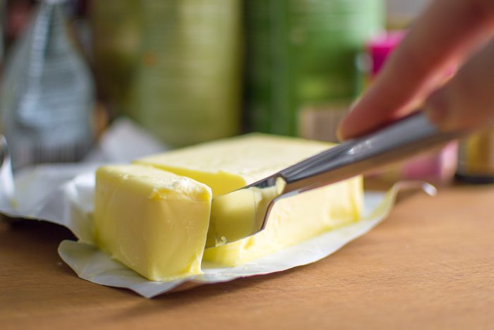 Cutting butter with a knife in closeup