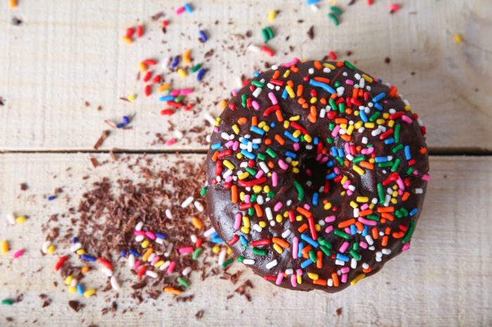 donut with sprinkles on a wooden background 