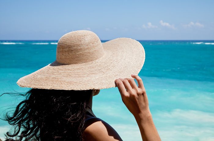 woman wearing wide-brimmed hat at the beach
