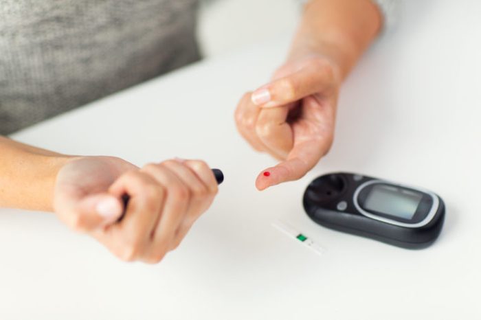 person doing a finger stick to test blood sugar
