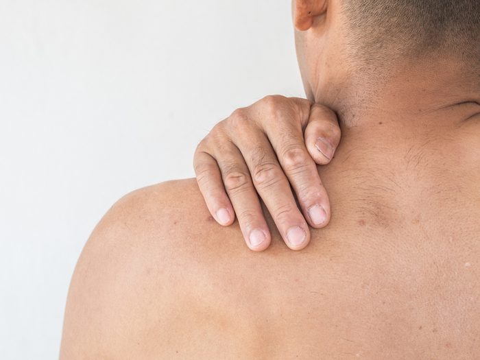 man massaging shoulder, back pain