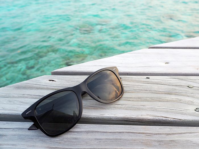 Sunglasses polarized lens on wooden deck over the sea