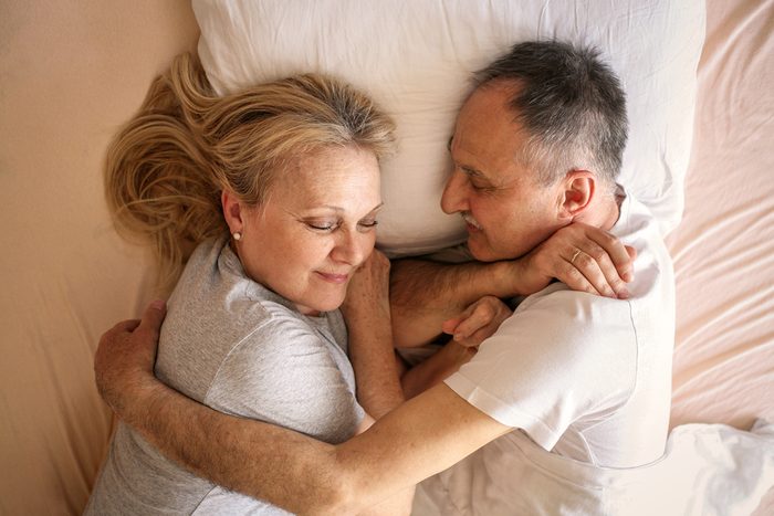 Senior couple sleeping together in bed. Senior couple sleep together on one pillow.