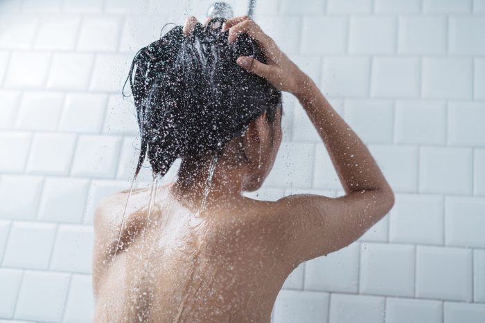 woman rinsing hair in shower