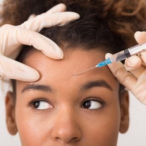 black diverse African-american woman getting botox injection in forehead