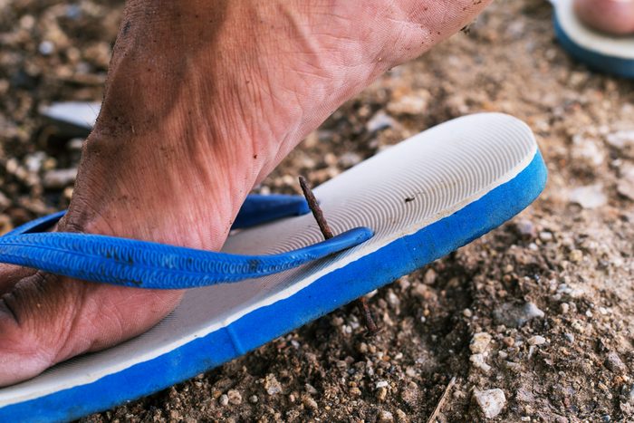 close up of nail through flip flop shoe