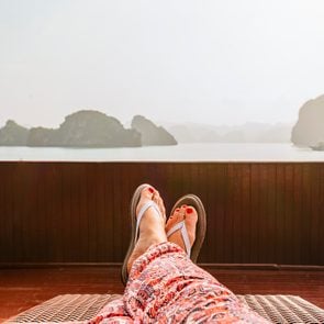 view of woman's legs laying outside wearing flip flops