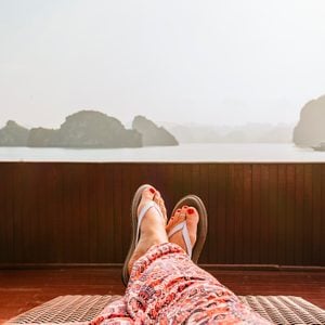 view of woman's legs laying outside wearing flip flops