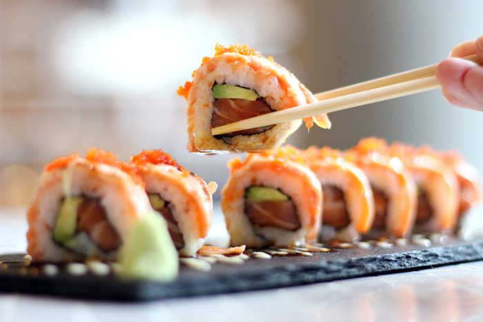 close up of sushi in chopsticks