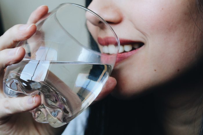 close up of woman drinking a glass of water