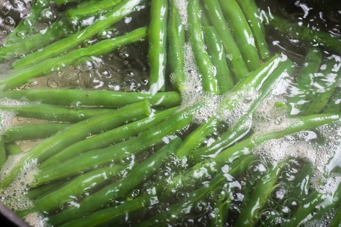 Fresh green beans boiling in water on stove