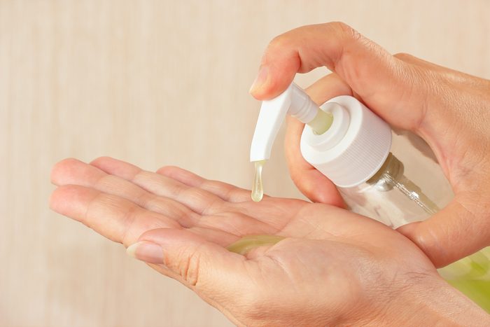 Female hands applying antibacterial liquid soap close up.